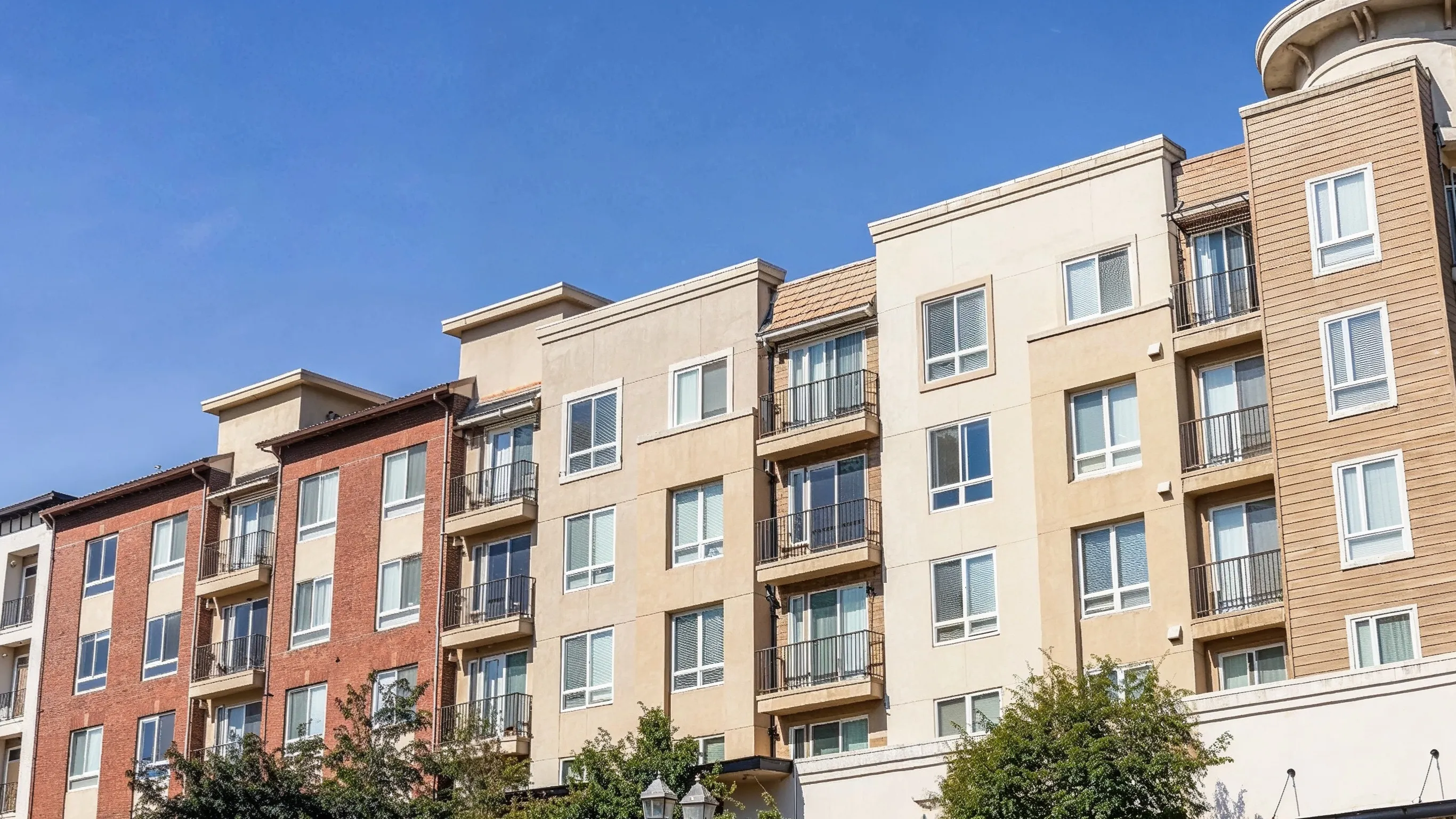 Before photo of condo remodeling project in Los Angeles with older multi-unit building exterior, balconies, stucco facade, residential windows, and dated condo property appearance
